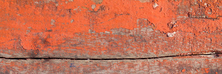 close up, macro shot of an old orange color painted peeling off from the natural wood plank texture...