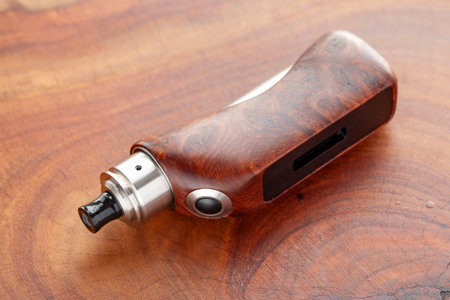 high end natural stabilized wood box mods with rebuildable dripping atomizer on natural wood texture background, vaporizer equipment, selective focusの写真素材