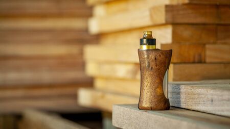 high end rebuildable dripping atomizer with stabilized natural walnut wood regulated box mods, vaping device, selective focusの写真素材