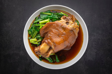 Kha Moo Pa Lo, Thai food, brown Chinese stewed pork leg in sweet brown sauce on dark tone texture...