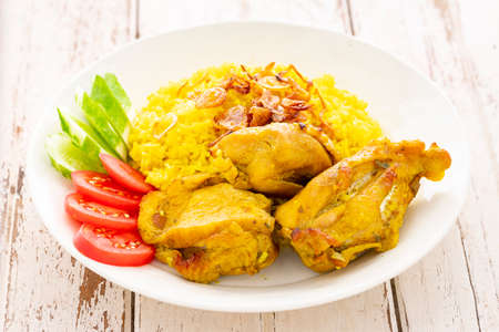 Khao Mok Gai, Thai Muslim version of Indian Biryani, fragrant yellow rice with chicken in white ceramic plate on white old wood texture background, Chicken Biryani, Biriani, Berianiの写真素材