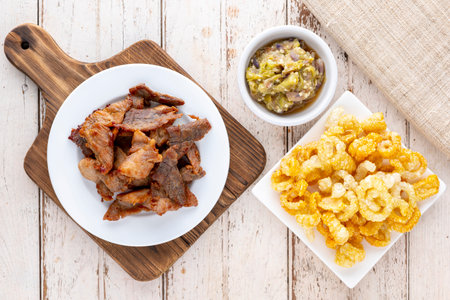 Nam Prik Num, Thai food, Northern Thai Green Chilli Dip with fried pork and crispy pork crackling on old white wood texture background, top view, flat layの写真素材