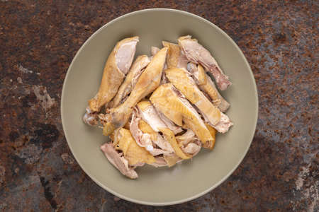 cut of boiled chicken in simply ceramic plate on rusty texture background, top view, flat layの写真素材
