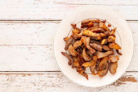 tasty fried pork in  ceramic plate on white wooden texture background with copy space for text, top view, flat layの写真素材
