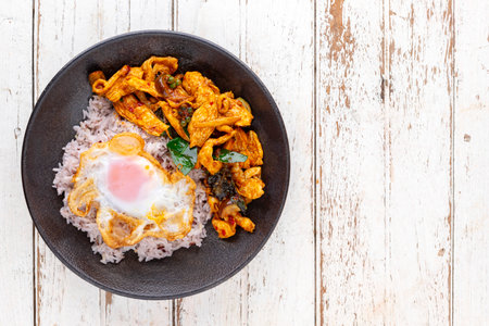 stir fried chicken with red curry paste, bergamot leaves, pepper with rice and egg in ceramic plate, top view, flat lay, copy space for text, Thai food, Gai Pad Prik Gaeng, Spicy Red Thai Stir Fryの写真素材