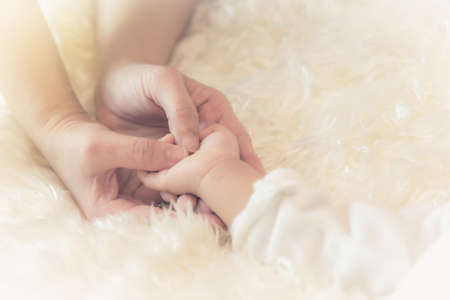 Touching hand, showing love, caring mother and child with each other.の写真素材