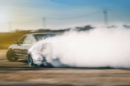 Drift driving is approaching the high speed curve and has a lot of smoke. This image is motion blur.の写真素材