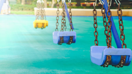 Blue swings in a playground With a green light in the park. Big city centerの写真素材