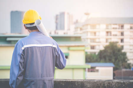 The young engineer is checking the blueprints carefully. For successの写真素材