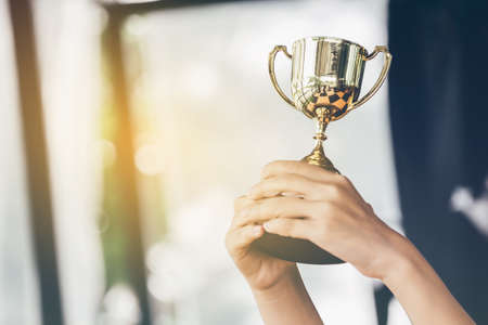 Teenage girls' hands are holding trophies, congratulations on success.Conception of victory in the competition.の写真素材