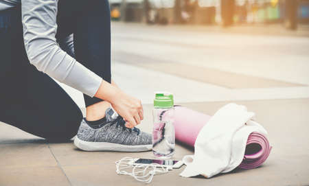 Women are preparing fitness equipment, sneakers, mats, water cylinders and handkerchiefs.Healthy Fitness Concept.の写真素材