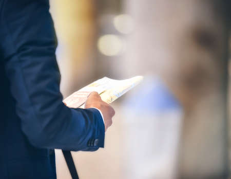 An Asian man holding a Thai passport and a map in his hand.の写真素材