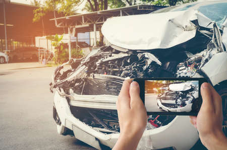 A man photographed his vehicle with accidental damage with a smart phone.Car Insurance Conceptの写真素材