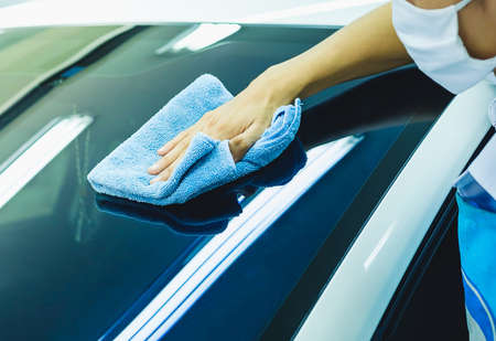 A man blur cleaning car with blue microfiber cloth, car detailing With care and attention.の写真素材