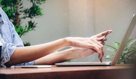 The hands of a woman holding a credit card in order to shop online.の写真素材