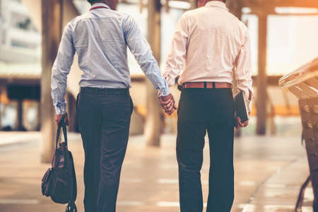 Two Asian business men are walking hand in hand and taking care of each other.The concept of sex couples is correct according to the rights of each person.の写真素材