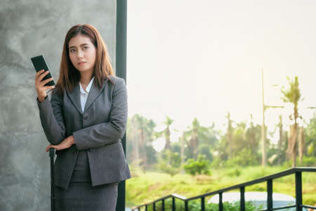 Asian women businessmen use smartphones to contact work and business.の写真素材