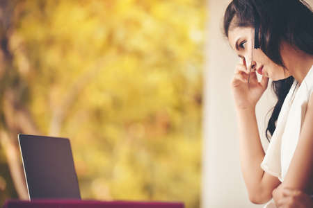 Asian female secretary is looking at a laptop and stresses her job.の写真素材