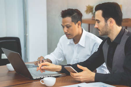 Two ethnic business people are discussing work for mutual success.Focus on the Caucasian man.の写真素材