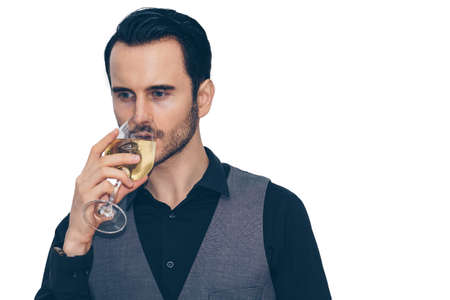 A businessman is holding a glass of wine and drinking with some thoughtful face.On a white background isolated.の写真素材