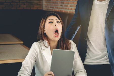 Asian business woman with unhappy expression during a business talk.She made a strange face to...