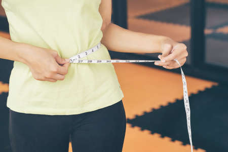 Teenage girls use their own waist measurement straps. To control the size and shape of yourself after exercise.の写真素材