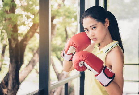 Asian cute girl boxer wearing gloves boxer, sparring with determination and seriousness.の写真素材