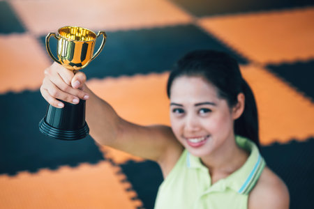 Teenage girls' hands are holding trophies, congratulations on success.Conception of victory in the...