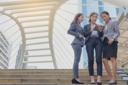 Businesspeople use cell phones to sit on a desk in the city. Contemporary communication concepts in the workplace.の写真素材