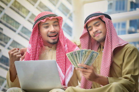 Two Arab businessmen rejoice in the success of their business ventures. Happy with the money...