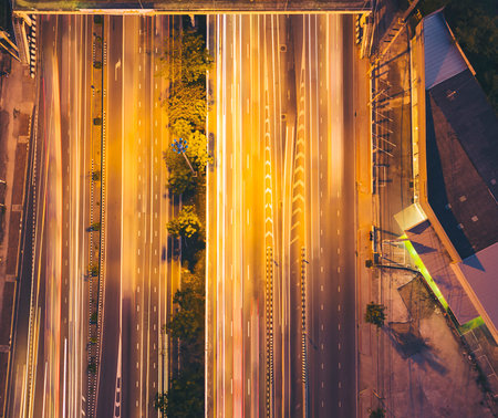A traffic overpass that crosses a road with a car is running in the background at a motion blur. Top...