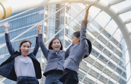 The group of business women is holding hands with great success.