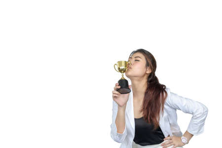 Asian businesswoman is delighted with her accomplishments, is kissing the trophy she receives. On white isolate backgroundの写真素材