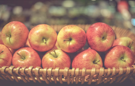Freshly colored apples are in rattan baskets.This image is soft focus.