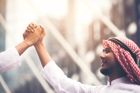 Arab businessmen shake hands and accept business deals for teamwork.focus on the hand.