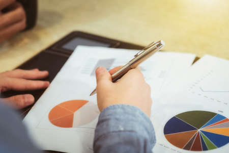 Businessman holding a pen is analyzing, business planner.For profit and stability of business sustainability.の写真素材