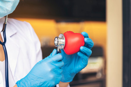Doctor with blue rubber gloves holding a red heart.Concepts about health care.