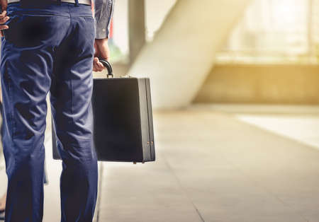 A businessman carrying a briefcase goes to work in his daily routine with determination and confidence.の写真素材