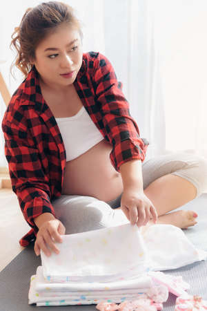 A pregnant woman is prepared for the things that are necessary for the child to be born.の写真素材