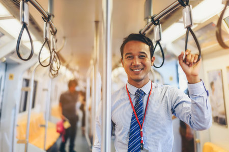 An Asian businessman is traveling a public train.の写真素材