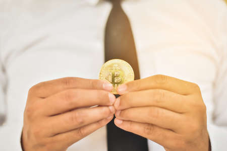 Hand of a businessman holding a bitcoin.The concept of money and exchange in cyberspace.の写真素材