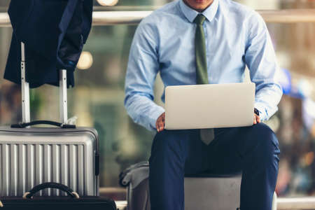 Asian businesspeople are using laptop to check their flights at the airport.focus on laptop.の写真素材