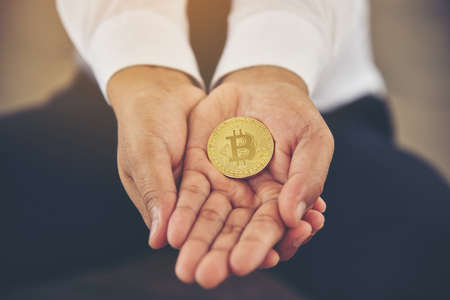 Hand of a businessman holding a bitcoin.The concept of money and exchange in cyberspace.の写真素材