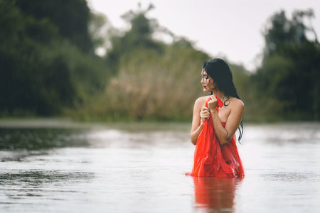 Asian woman in a red bathrobe and enjoy nature in the wild.