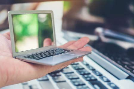 Hand of a man holding a laptop with a laptop care concept for safe use.の写真素材