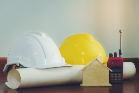 White and yellow helmet with wooden houses and various devices that are placed on a wooden floor.