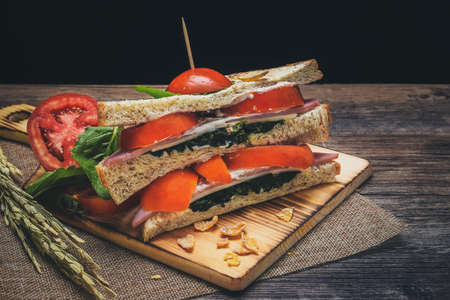 Sandwiches with spinach and tomatoes have cream sauce on the wood floor that looks inviting.の写真素材