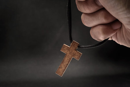 The crucifix is in the hands of a man who is praying for the blessing of his god with faith.