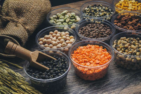 Different types of cereal beans that have a variety of nutritional benefits on the wooden floor.の写真素材
