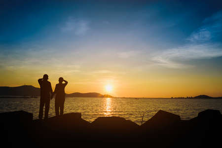 Silhouette of a lover watching the sunset in the evening.の写真素材